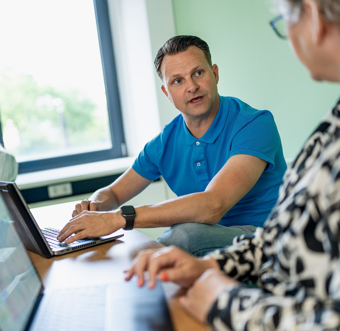 verzekeringsadviseur in een klantgesprek met laptop