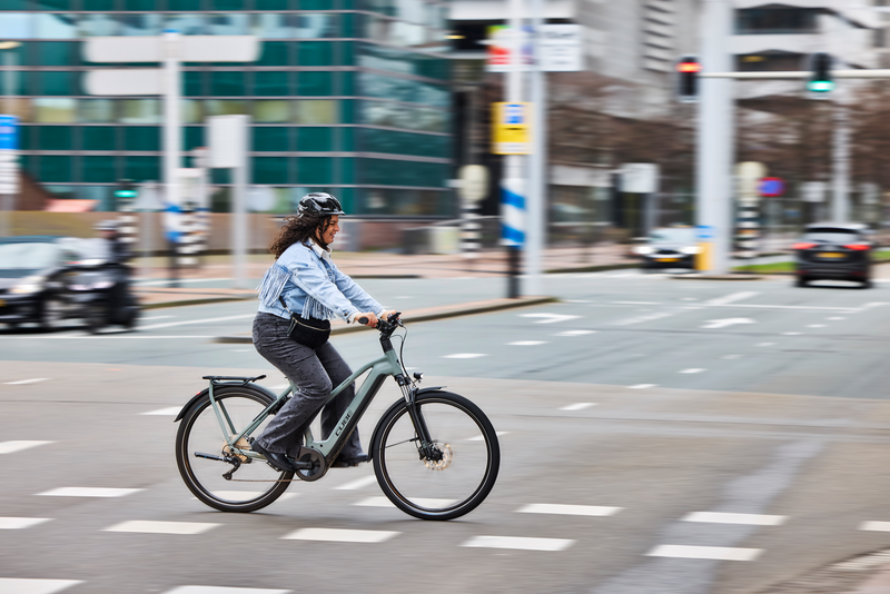 vrouw fietst met helm op in de stad